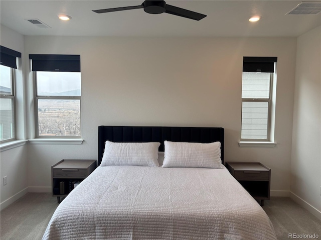 carpeted bedroom with ceiling fan and multiple windows