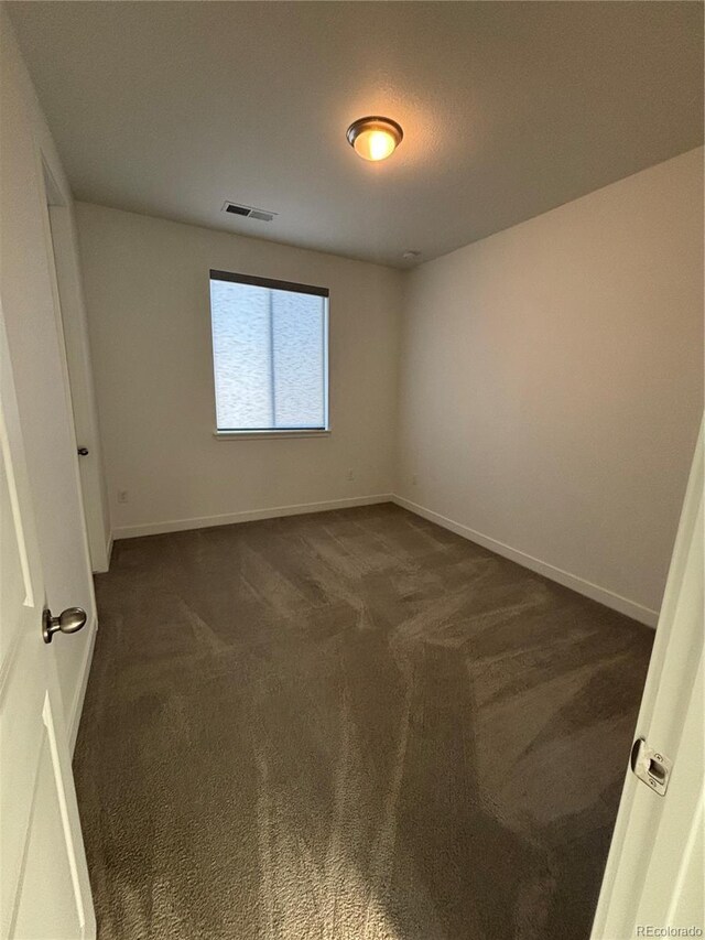 15682 W Girard Ave, Morrison, CO 80465 - unfurnished room featuring baseboards, visible vents, and dark carpet
