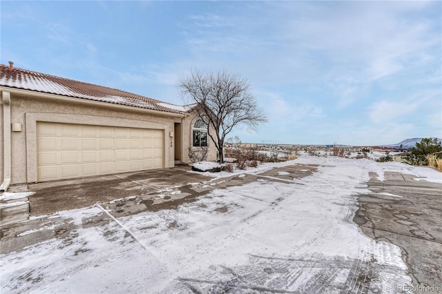 snow covered property featuring a garage