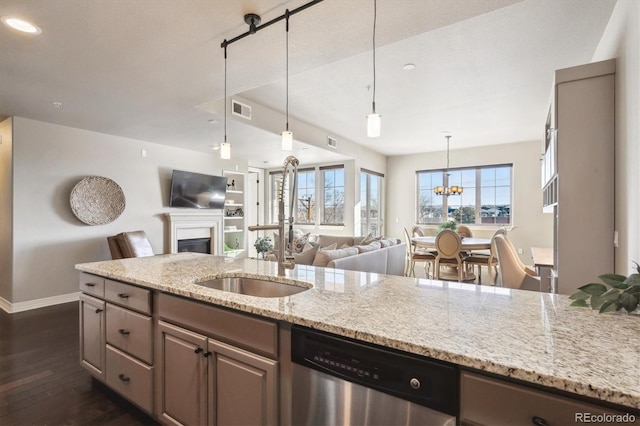 kitchen with pendant lighting, sink, dishwasher, light stone countertops, and dark hardwood / wood-style flooring