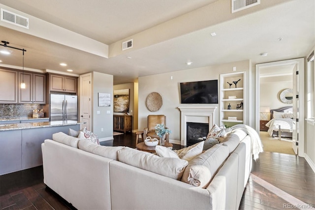 living room featuring dark hardwood / wood-style floors and built in features