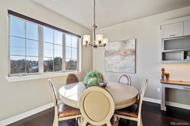 dining room with dark wood-type flooring and an inviting chandelier