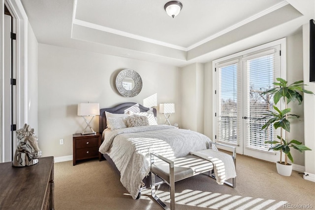 carpeted bedroom featuring a raised ceiling, ornamental molding, and access to outside