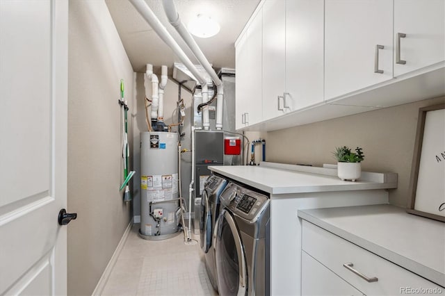 clothes washing area with cabinets, washing machine and dryer, and water heater