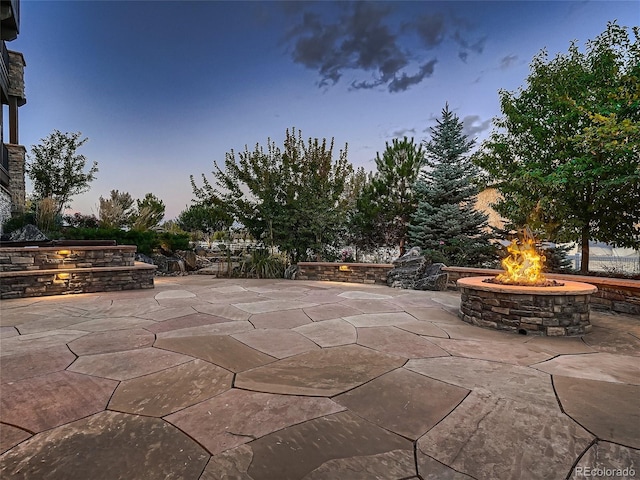 patio terrace at dusk featuring a fire pit