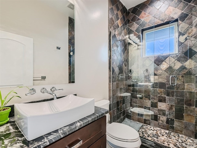 bathroom with toilet, a shower with shower door, and vanity