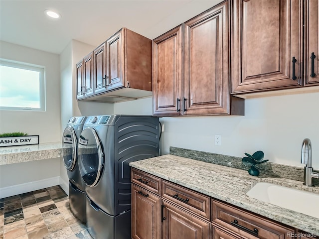 washroom featuring washer and dryer, cabinets, and sink