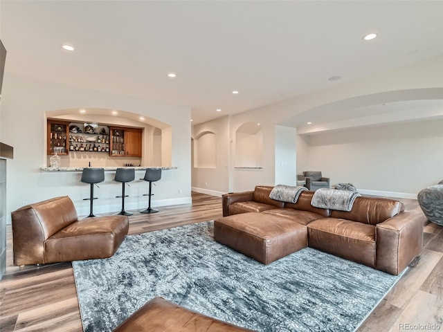 living room featuring bar area and light hardwood / wood-style flooring