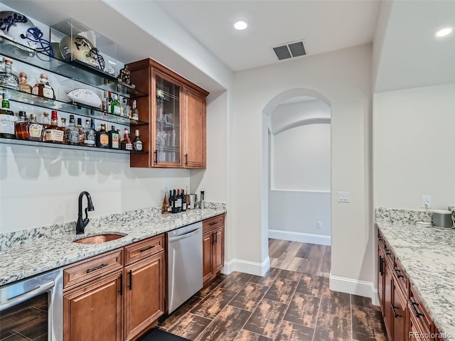 bar featuring sink, light stone countertops, dishwasher, and beverage cooler