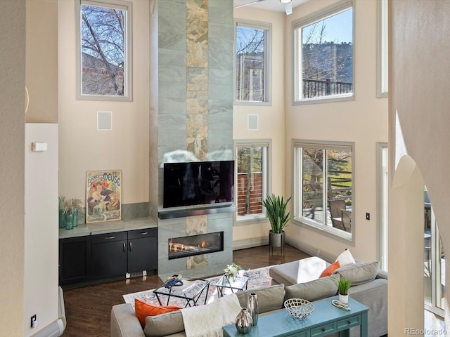 4825 6th St, Boulder, CO 80304 - living area featuring arched walkways, dark wood finished floors, a high end fireplace, and a high ceiling