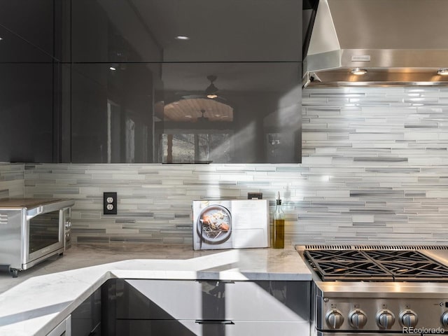 4825 6th St, Boulder, CO 80304 - kitchen with wall chimney range hood, backsplash, light stone countertops, and dark cabinetry