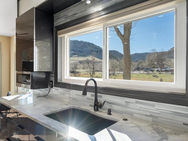 4825 6th St, Boulder, CO 80304 - kitchen featuring a mountain view, decorative backsplash, light stone counters, and plenty of natural light