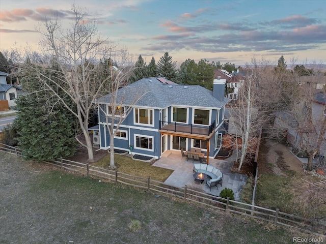 4825 6th St, Boulder, CO 80304 - back of house at dusk featuring a balcony, a patio area, a fenced backyard, and a chimney