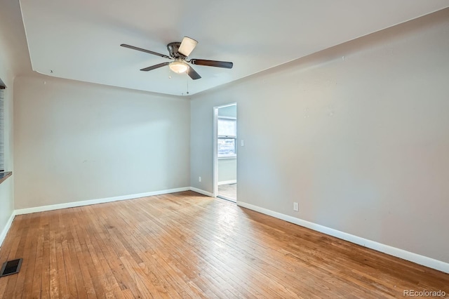 unfurnished room featuring hardwood / wood-style flooring, baseboards, visible vents, and ceiling fan