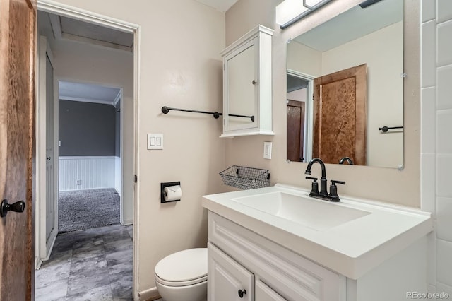 bathroom featuring wainscoting, vanity, and toilet