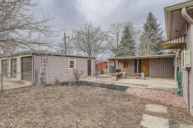 view of yard featuring a patio area, fence, and an outbuilding