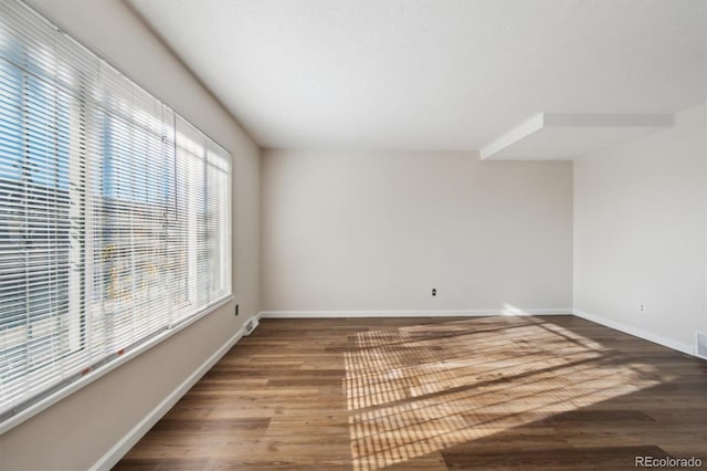 unfurnished room featuring baseboards and wood finished floors