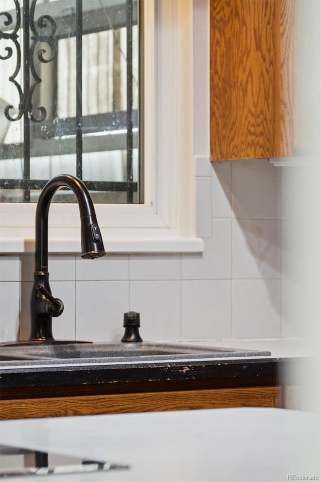 room details featuring light countertops, tasteful backsplash, and a sink