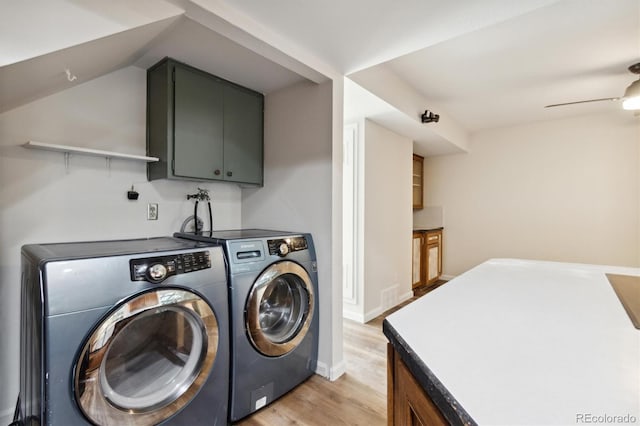 laundry area with cabinet space, light wood-style flooring, ceiling fan, washer and dryer, and baseboards