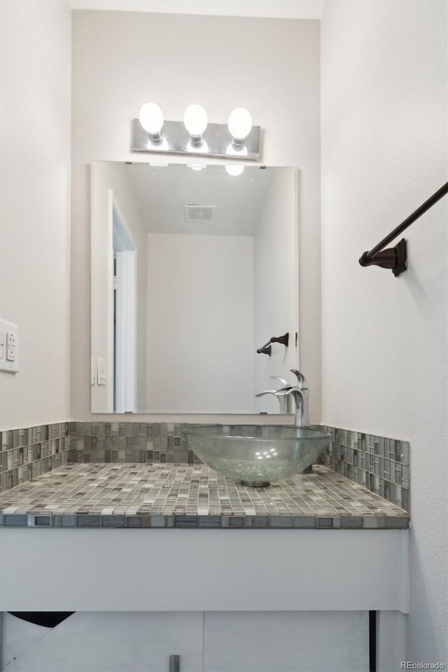 bathroom with tasteful backsplash and vanity