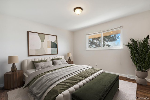 bedroom with visible vents, baseboards, and wood finished floors