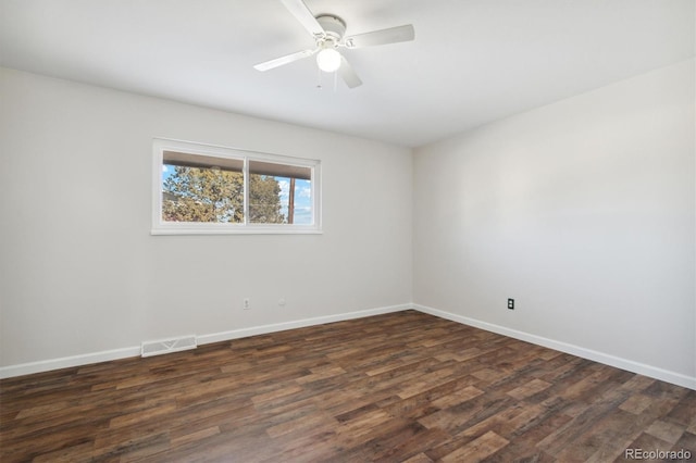 spare room featuring dark wood-style floors, baseboards, visible vents, and ceiling fan