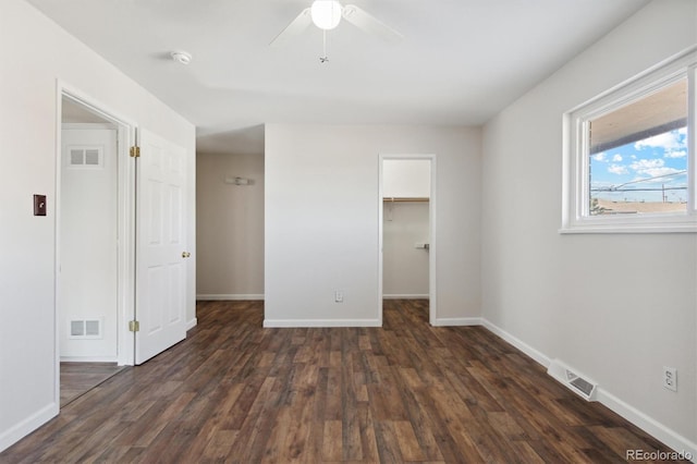 unfurnished bedroom featuring baseboards, visible vents, and dark wood-style flooring