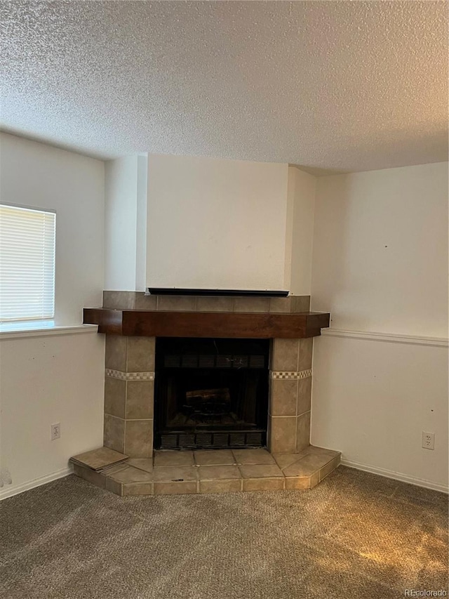 details with a textured ceiling, carpet floors, a fireplace, and baseboards