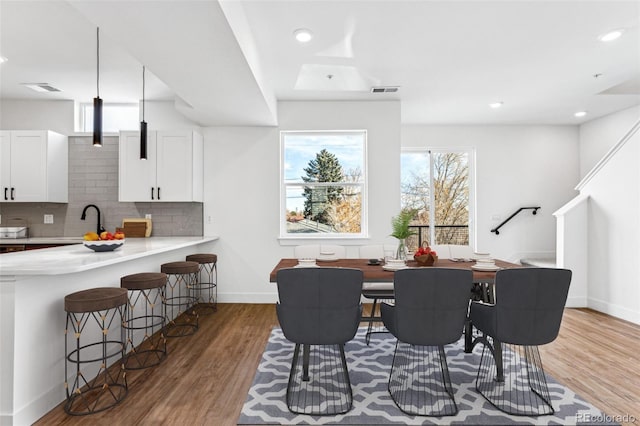 dining space with light wood-type flooring and sink