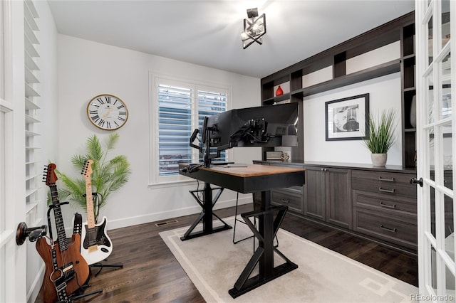 home office featuring dark hardwood / wood-style flooring and built in features