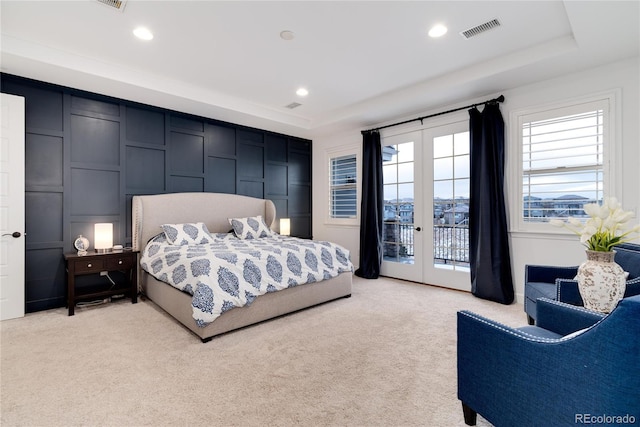 bedroom featuring light carpet, french doors, access to outside, and a raised ceiling