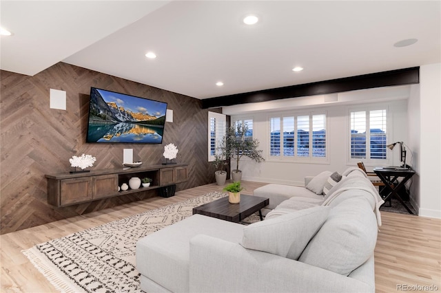 living room with beamed ceiling, wood walls, and light hardwood / wood-style floors