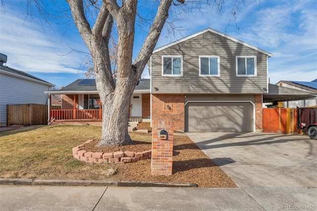 view of front of house featuring a porch, a garage, and a front lawn