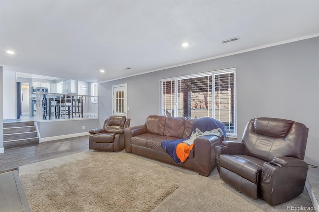 living room with wood-type flooring and ornamental molding