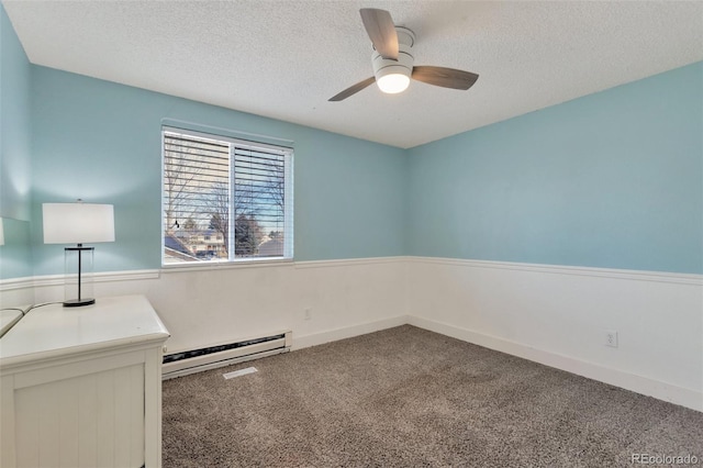 carpeted empty room featuring a textured ceiling, ceiling fan, and a baseboard heating unit