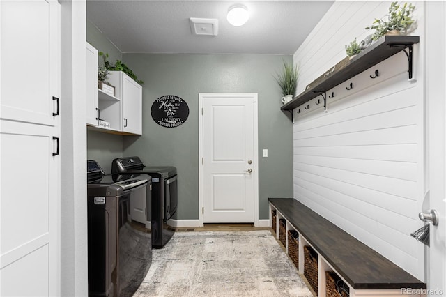 washroom with washing machine and dryer and cabinets