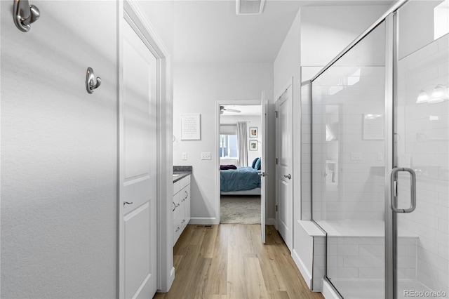 bathroom featuring vanity, a shower with shower door, and hardwood / wood-style floors