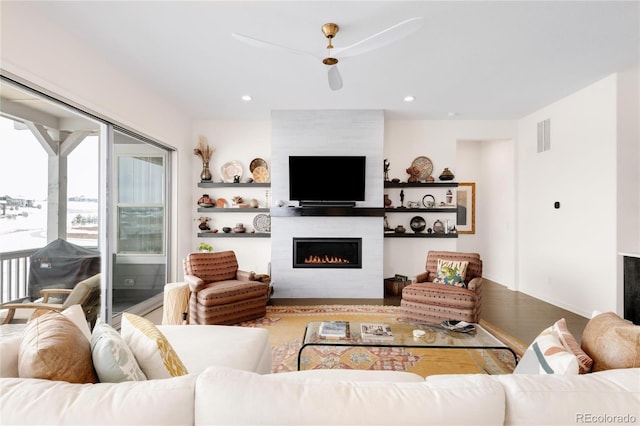 living room featuring visible vents, recessed lighting, and a large fireplace