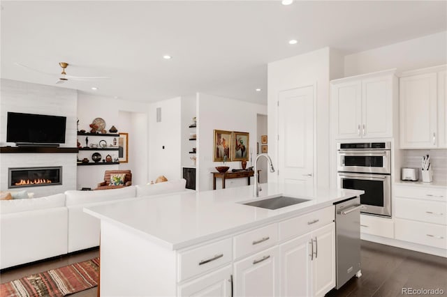 kitchen featuring open floor plan, a center island with sink, appliances with stainless steel finishes, and a sink