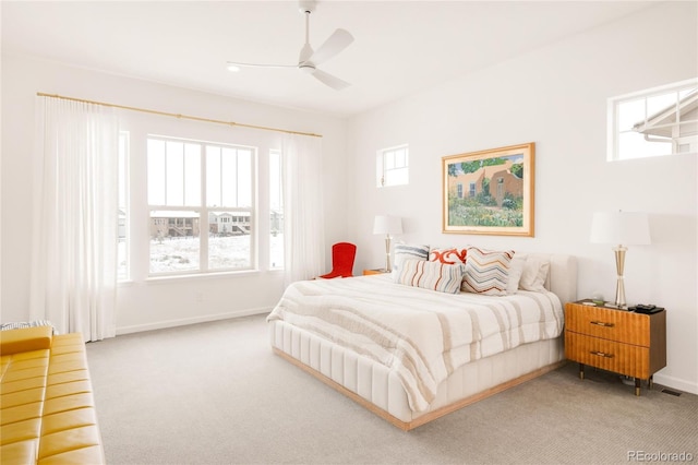 bedroom with light colored carpet, baseboards, and multiple windows