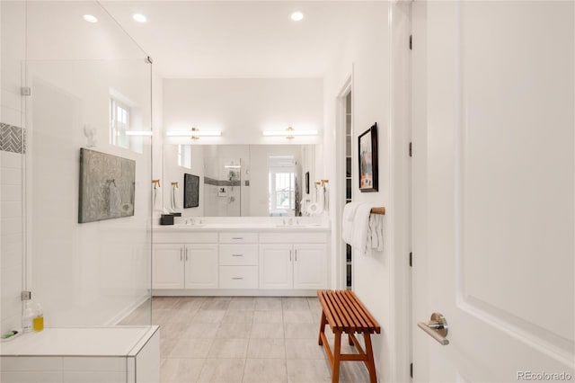 bathroom with double vanity, recessed lighting, a stall shower, and a sink