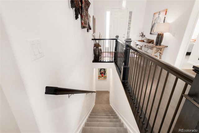 staircase featuring carpet flooring and baseboards