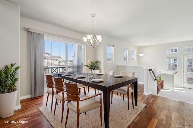 dining area with hardwood / wood-style floors and a notable chandelier