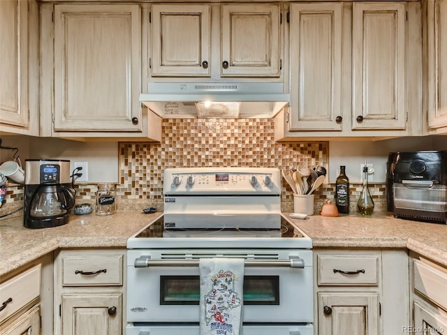 kitchen featuring stainless steel range with electric stovetop, light brown cabinets, and decorative backsplash