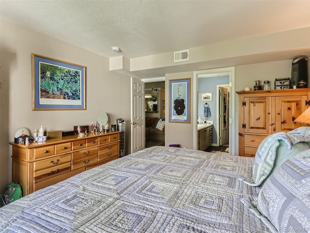 bedroom with connected bathroom and a textured ceiling