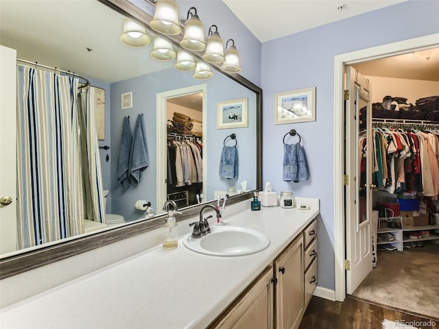 bathroom with hardwood / wood-style floors, vanity, and toilet