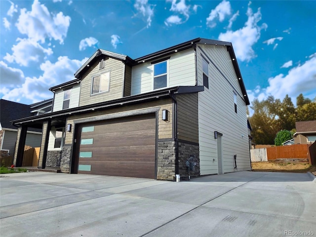 5550 Wetlands Dr, Longmont, CO 80504 - view of front facade featuring an attached garage, stone siding, and concrete driveway