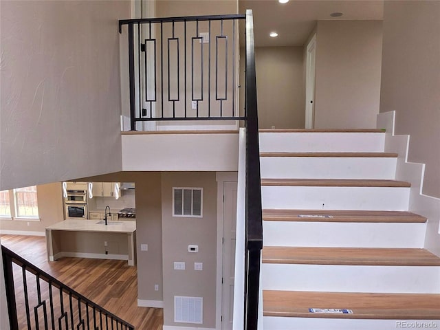 5550 Wetlands Dr, Longmont, CO 80504 - staircase with wood finished floors, recessed lighting, and a towering ceiling