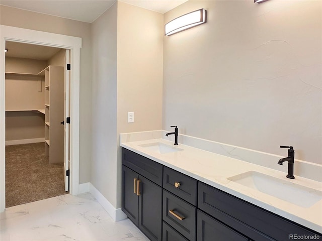 5550 Wetlands Dr, Longmont, CO 80504 - bathroom featuring double vanity, marble finish floors, and a spacious closet