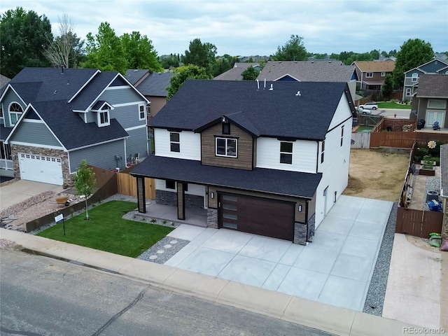 5550 Wetlands Dr, Longmont, CO 80504 - view of front of house with stone siding, a garage, a shingled roof, and a residential view